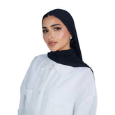 Woman wearing a black hijab and white shirt on a white background
