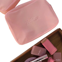 Pink cosmetic case with 'Humen' branding, containing makeup items on a white background.